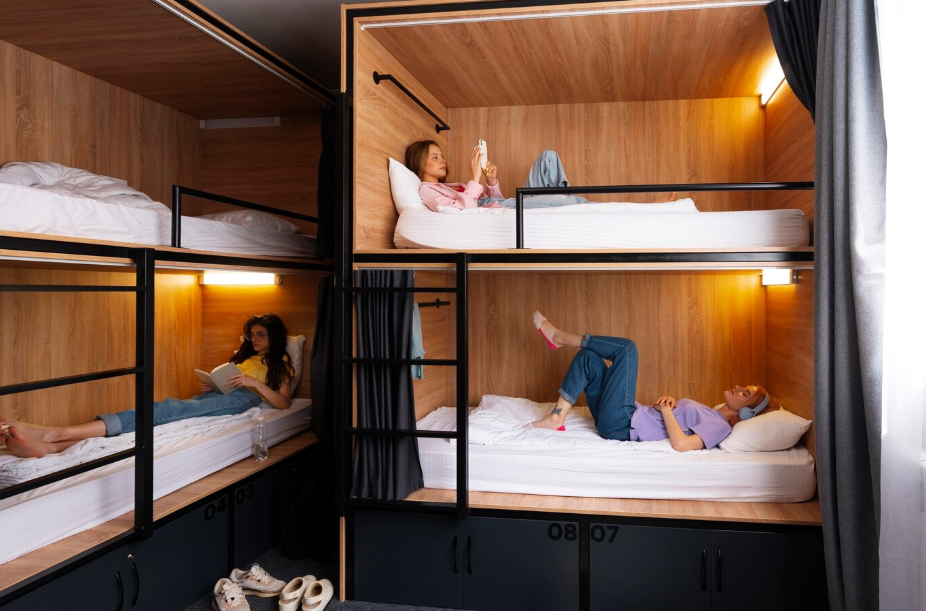 Travelers relaxing in modern wooden bunk beds at a shared hostel, a budget-friendly accommodation option for group trips