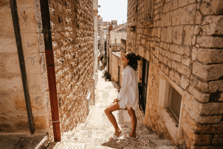 Woman exploring a historic stone alley in Europe, representing the culture-seeking travel style for curious travelers.