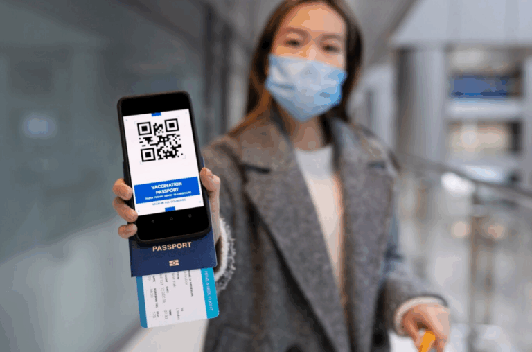 Woman at airport wearing a mask, holding a smartphone with a digital vaccination passport, passport, and boarding pass