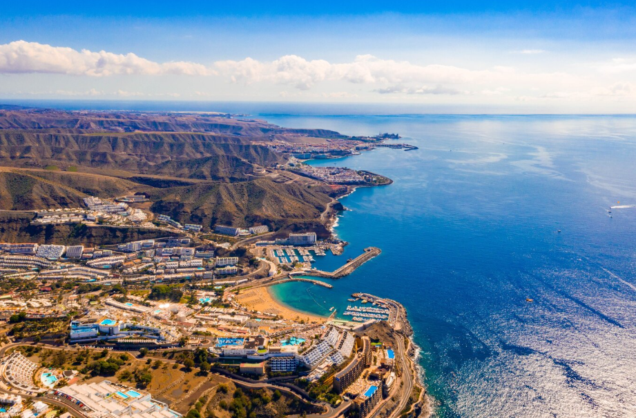Aerial view of Gran Canaria in the Canary Islands, Spain, showing rugged coastline, beach resorts, marinas, and turquoise waters