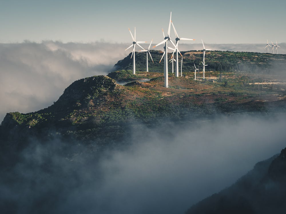 Wind turbines on a mist-covered mountain ridge in Madeira, Portugal