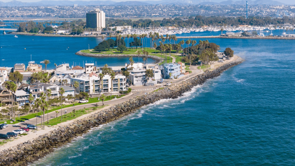 Aerial view of coastal San Diego featuring palm-lined streets, oceanfront homes, and a marina—perfect starting point for a California coastal road trip itinerary.