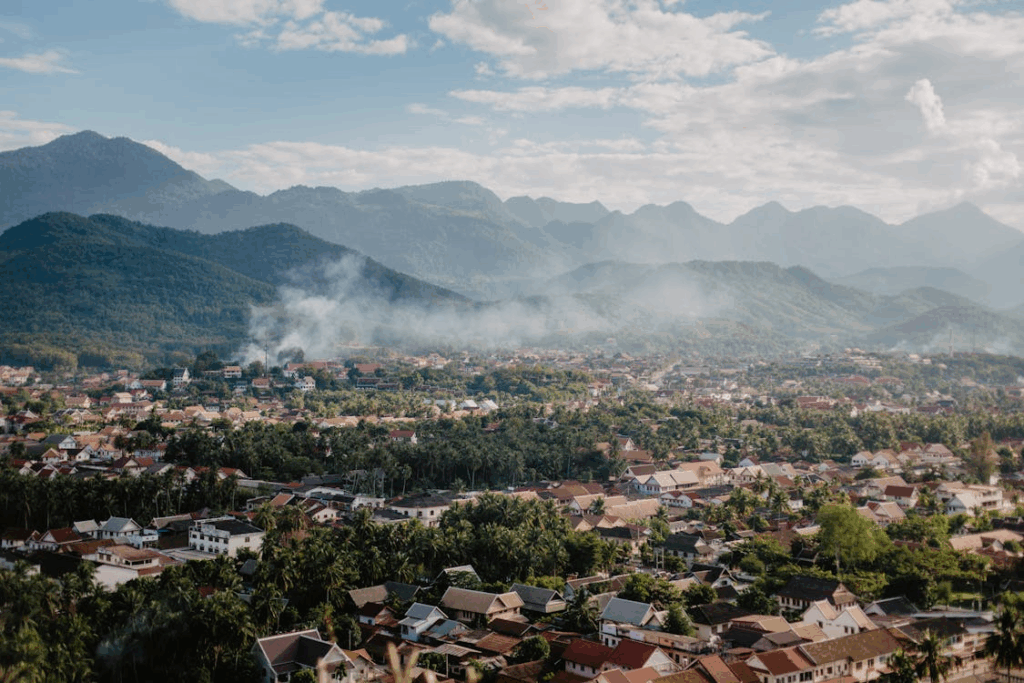 Panoramic view of Luang Prabang, Laos with lush greenery and traditional rooftops, an ideal Bali alternative in Southeast Asia.
