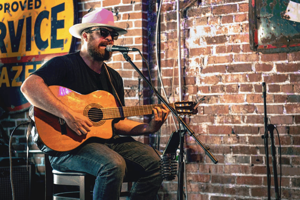 Musician performing live in a Nashville honky-tonk bar, capturing the heart of the Nashville country music scene.