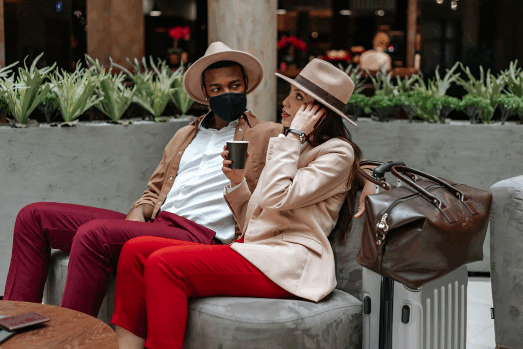 Stylish travelers sitting in an airport lounge with luggage
