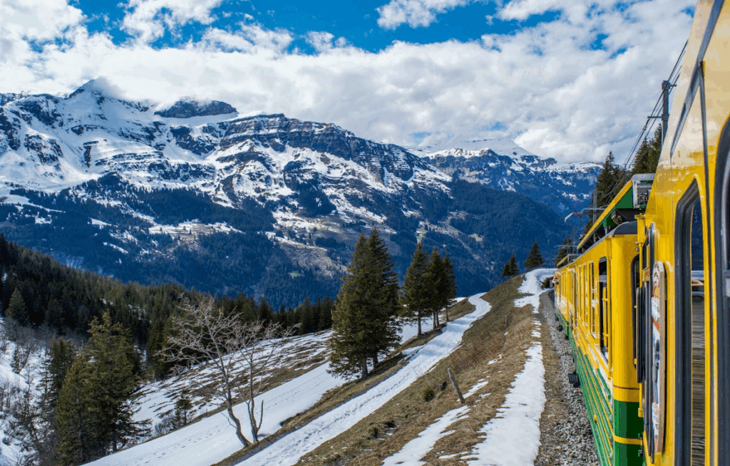 Scenic train ride through the snow-covered Swiss Alps with panoramic mountain views