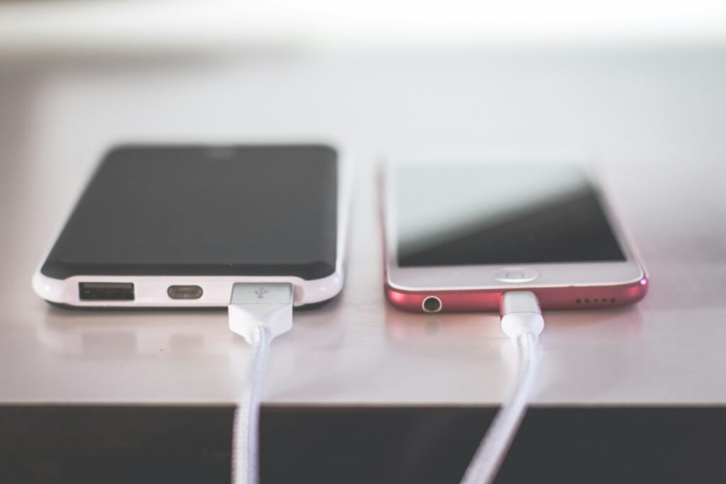 two phones on chargers on white table