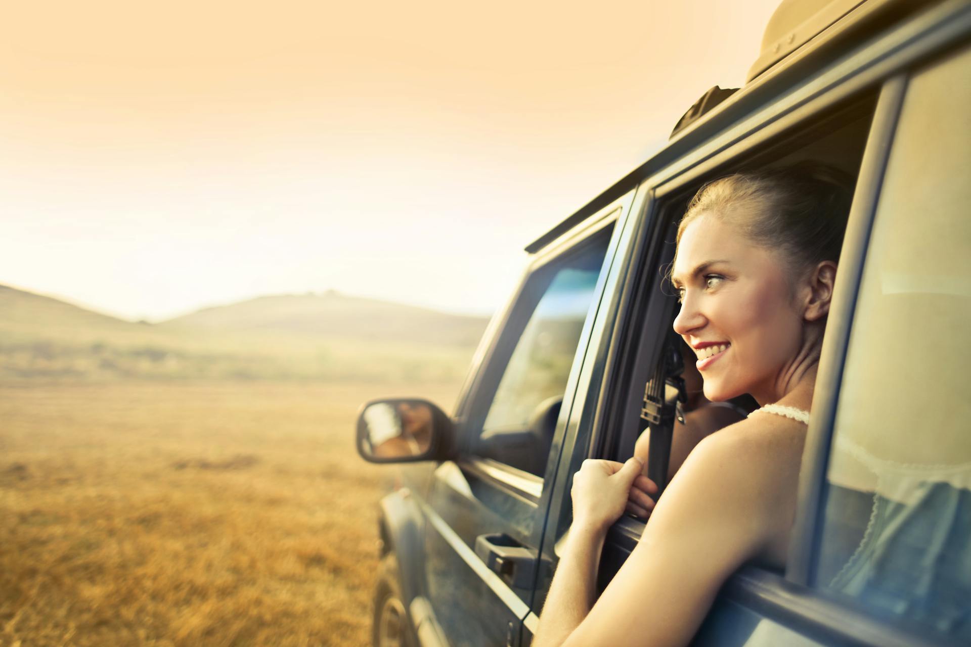 woman in car enjoying road trip