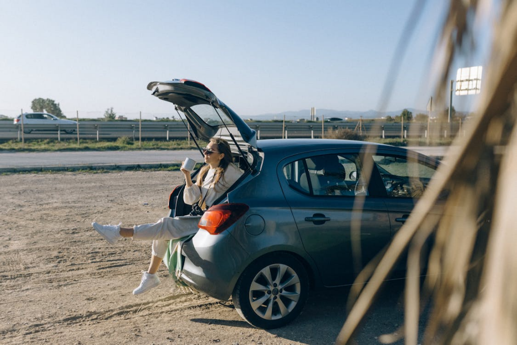 Traveler taking a break inside a rental car while on a road trip abroad.