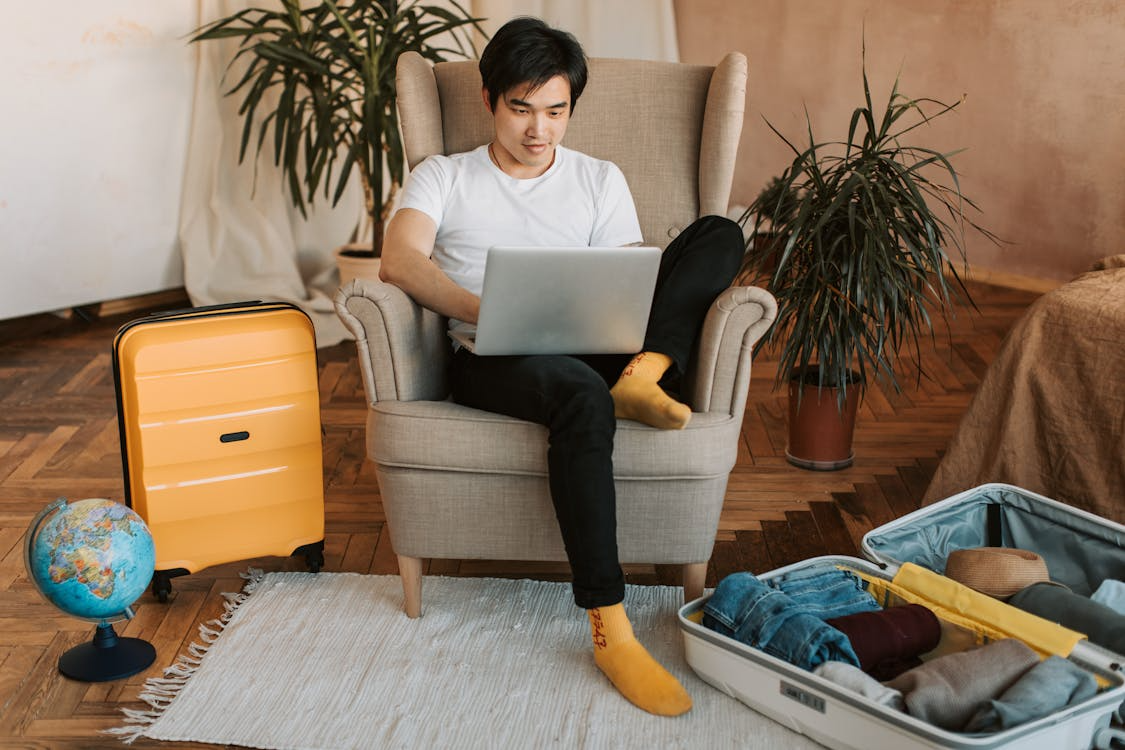 Traveler researching how far in advance to book hotels while packing for a trip.