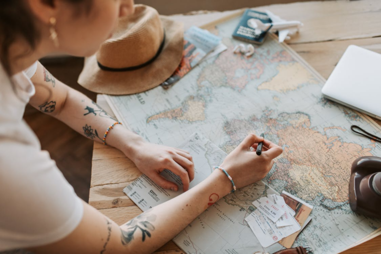 Traveler marking a map to create a relaxed travel itinerary for her next trip.