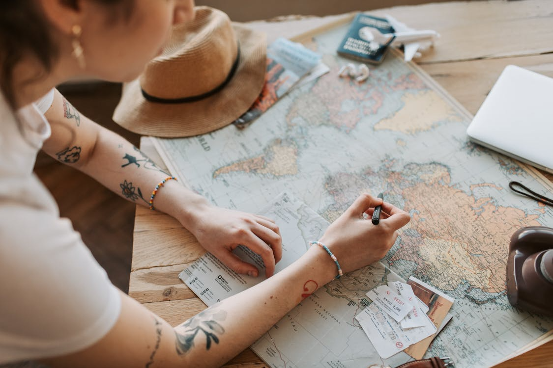 Traveler marking a map to create a relaxed travel itinerary for her next trip.