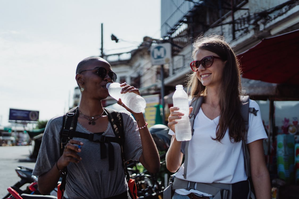 Travelers drinking water to stay healthy and hydrated while traveling abroad.