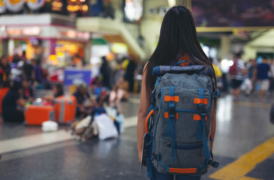 Solo female traveler in a train station in one of the safest countries for solo female travelers.