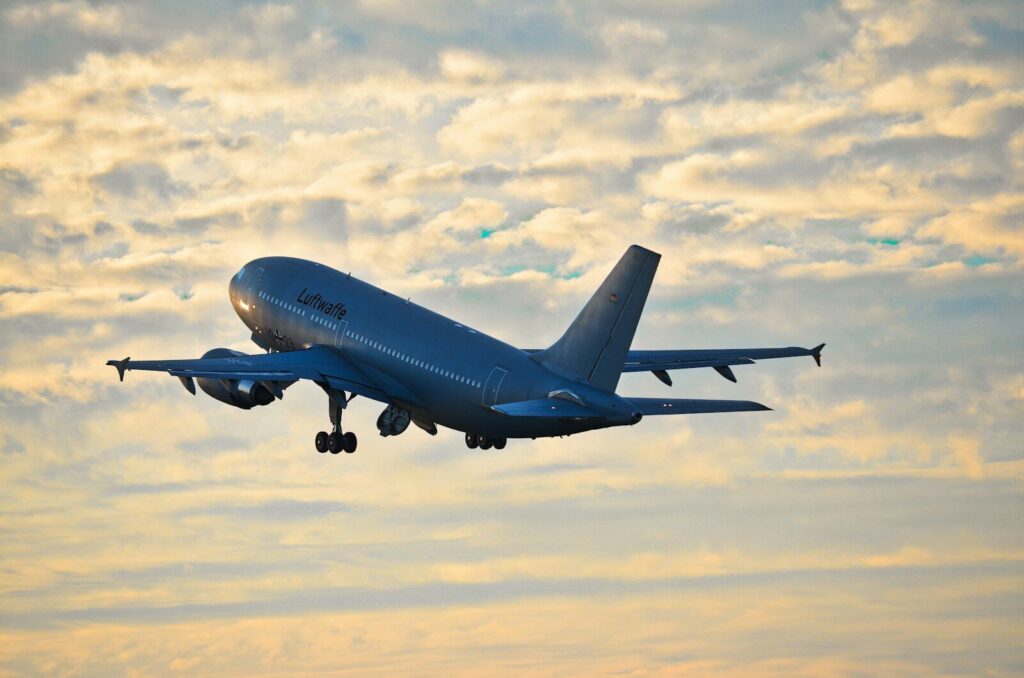 A large airplane takes off against a cloudy sky.