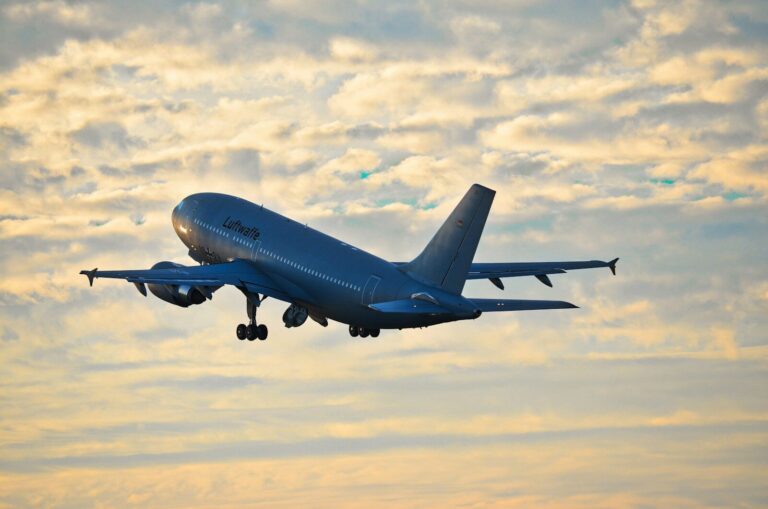 A large airplane takes off against a cloudy sky.