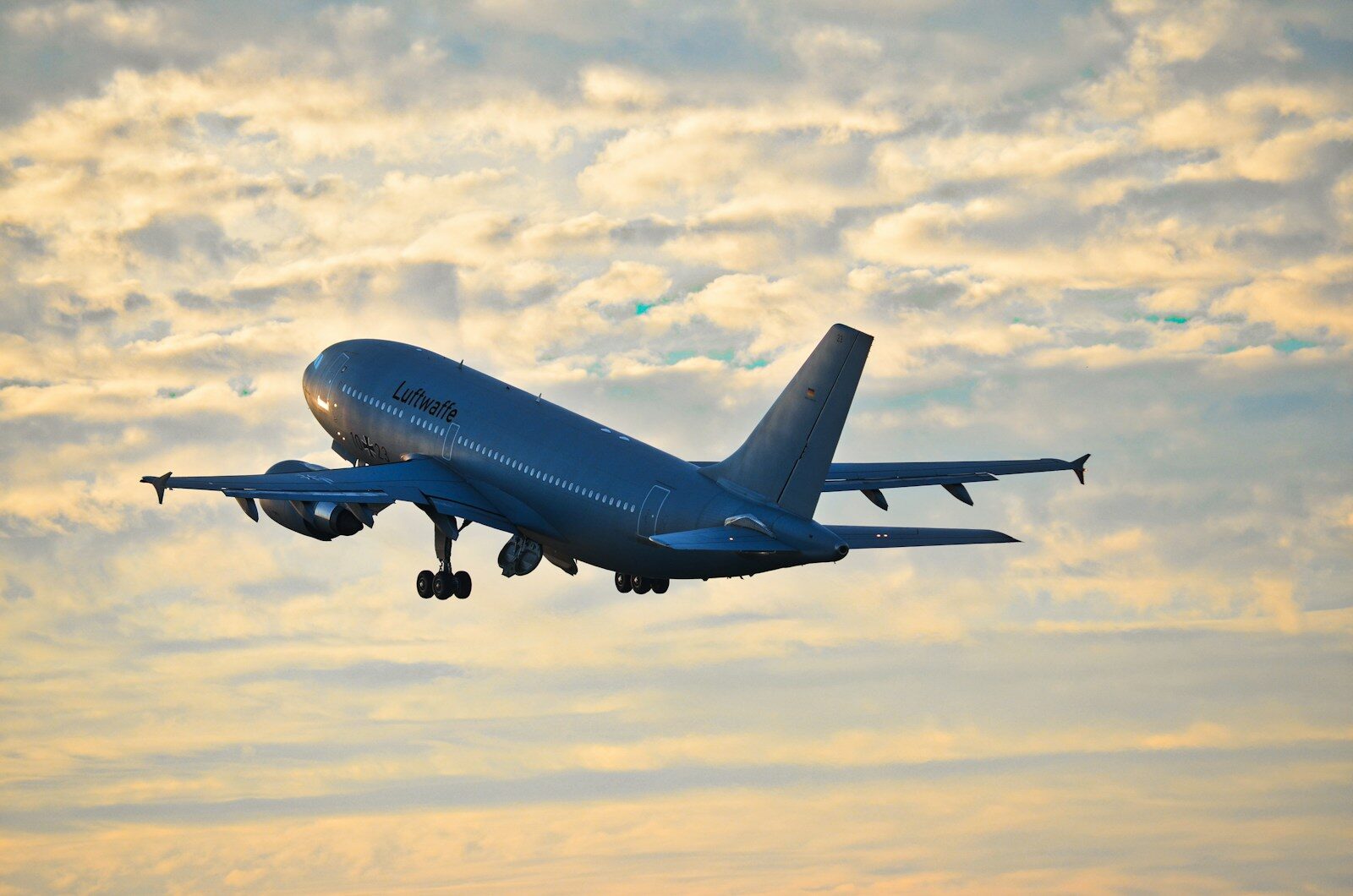 A large airplane takes off against a cloudy sky.